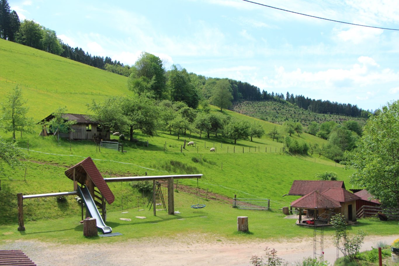 Der große Spielplatz lädt jung und alt zum Spielen ein. Rutschen, schaukeln, klettern, Trettraktor fahren, Sandburg bauen, Basketball spiele