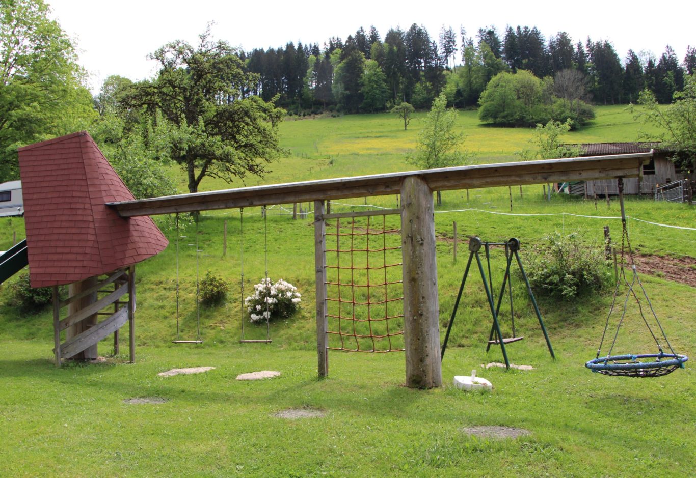 Der große Spielplatz lädt jung und alt zum Spielen ein. Rutschen, schaukeln, klettern, Trettraktor fahren, Sandburg bauen, Basketball spiele
