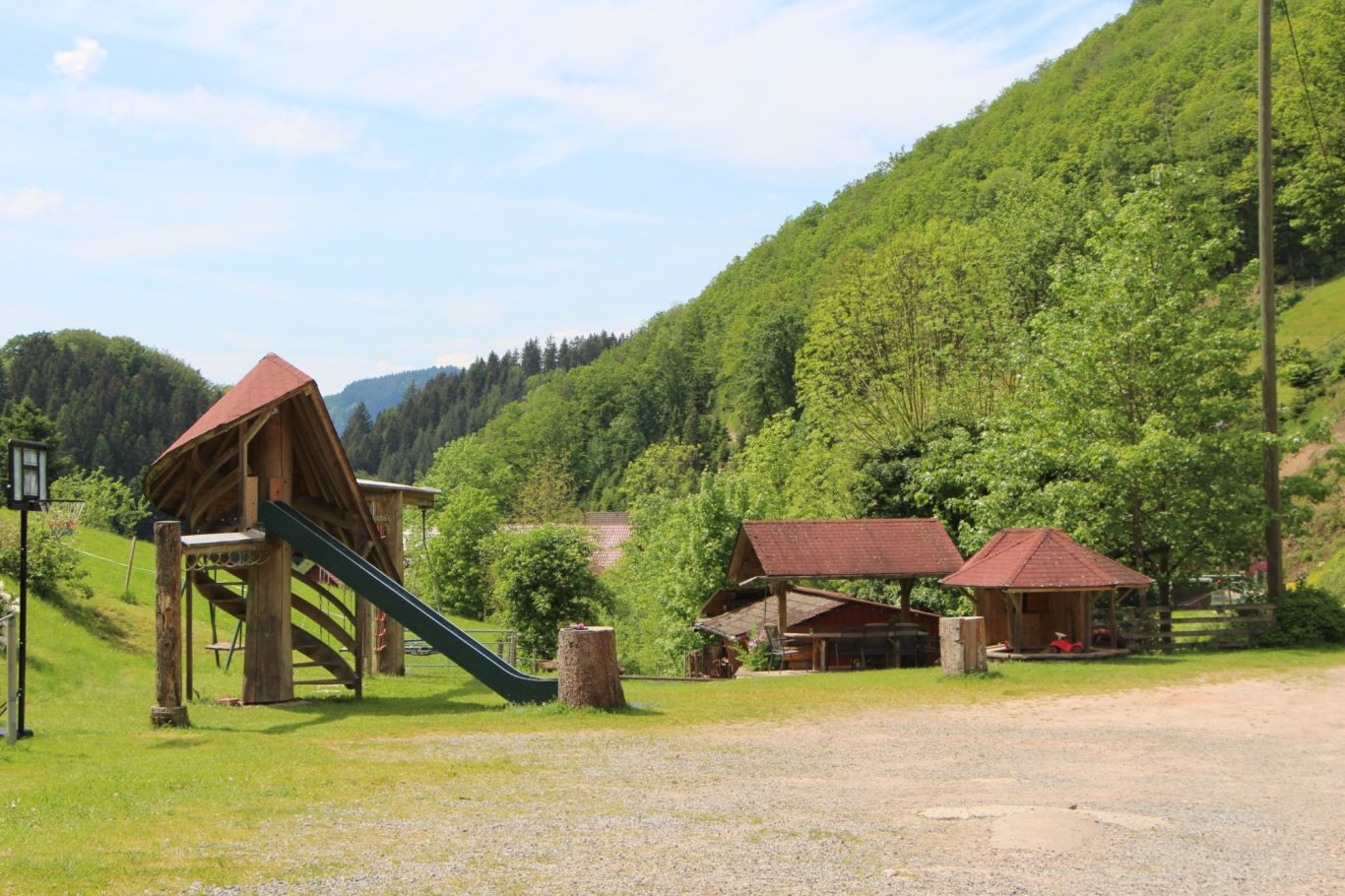 Der große Spielplatz lädt jung und alt zum Spielen ein. Rutschen, schaukeln, klettern, Trettraktor fahren, Sandburg bauen, Basketball spiele